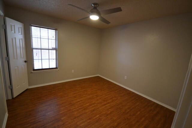 spare room featuring a textured ceiling, dark wood-type flooring, and ceiling fan