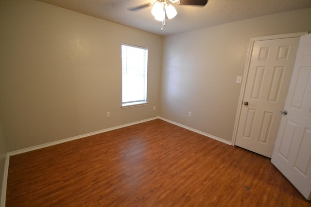 unfurnished room with ceiling fan, dark hardwood / wood-style floors, and a textured ceiling