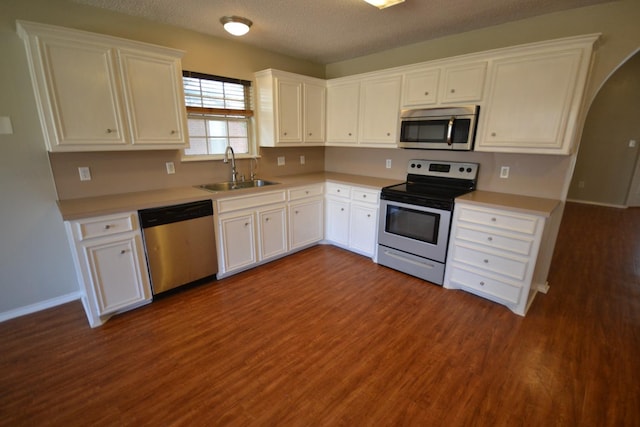 kitchen featuring white cabinetry, appliances with stainless steel finishes, sink, and dark hardwood / wood-style floors