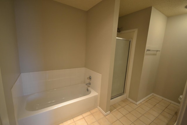 bathroom featuring tile patterned floors, toilet, a textured ceiling, and plus walk in shower