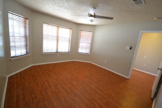 unfurnished room with ceiling fan, wood-type flooring, and a textured ceiling