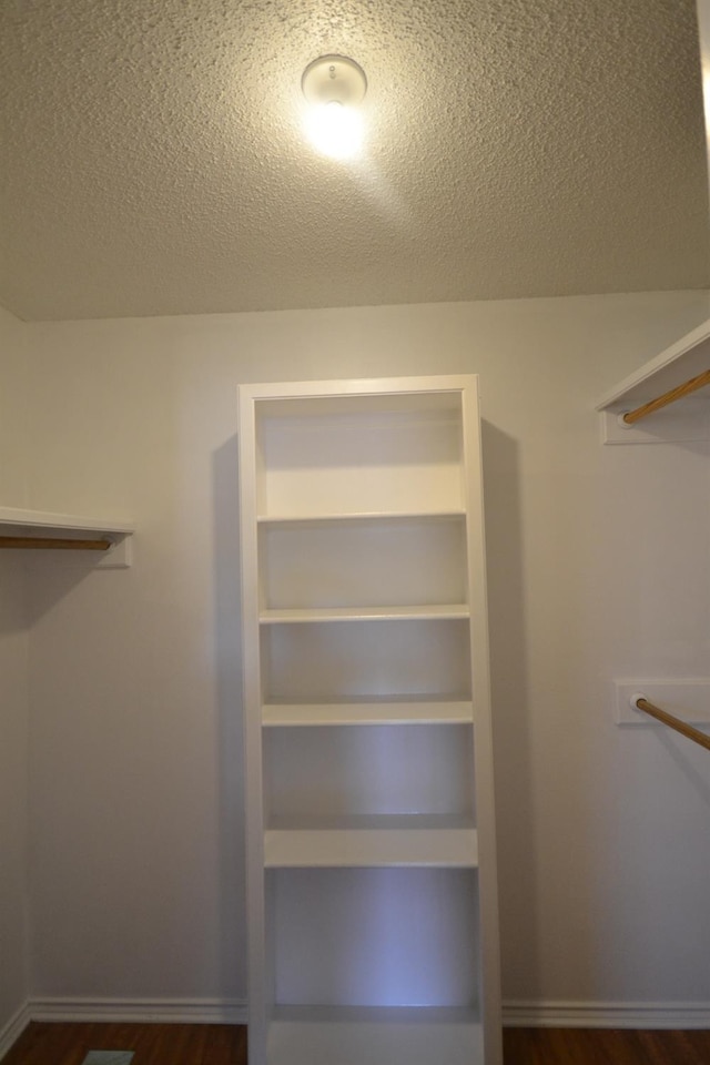 walk in closet featuring dark wood-type flooring