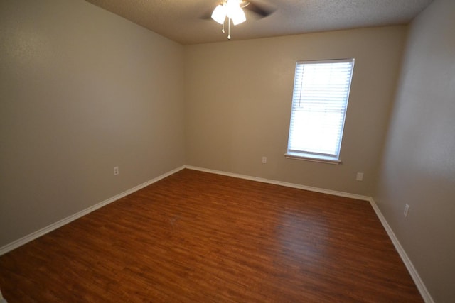 unfurnished room with ceiling fan, a textured ceiling, and dark hardwood / wood-style flooring