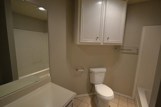 bathroom with tile patterned flooring, a bathing tub, and toilet