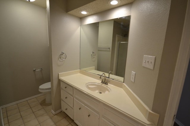 bathroom with vanity, tile patterned floors, toilet, and walk in shower