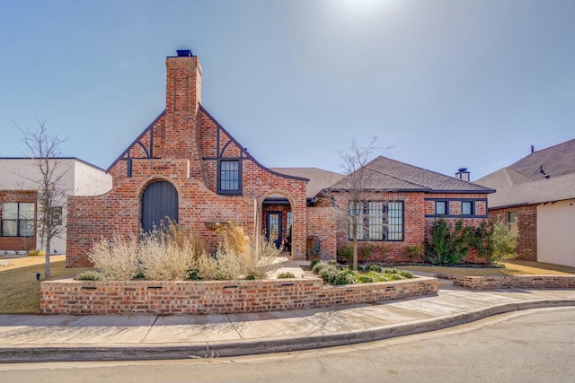 4309 136th St, Lubbock, TX 79423 - tudor-style house featuring brick siding and a chimney
