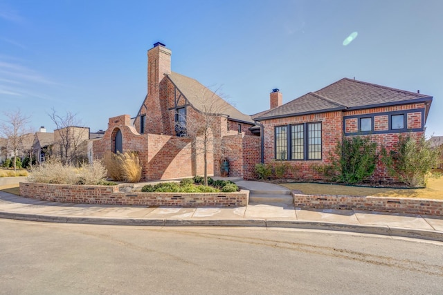 4309 136th St, Lubbock, TX 79423 - view of front of home with brick siding, a chimney, and a shingled roof