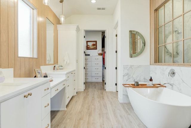 4309 136th St, Lubbock, TX 79423 - bathroom with wood finished floors, a freestanding tub, and two vanities