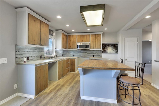 kitchen featuring a kitchen island, backsplash, and light hardwood / wood-style flooring