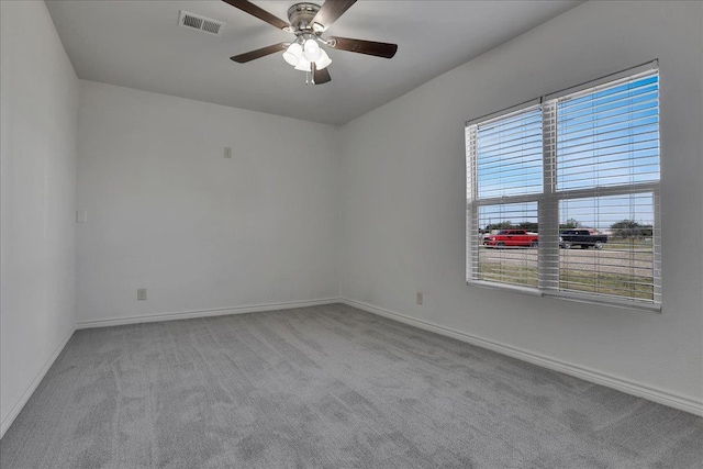 empty room with a healthy amount of sunlight, light carpet, and ceiling fan