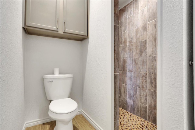 bathroom featuring toilet and a tile shower