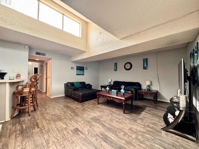 living room with hardwood / wood-style flooring and a towering ceiling