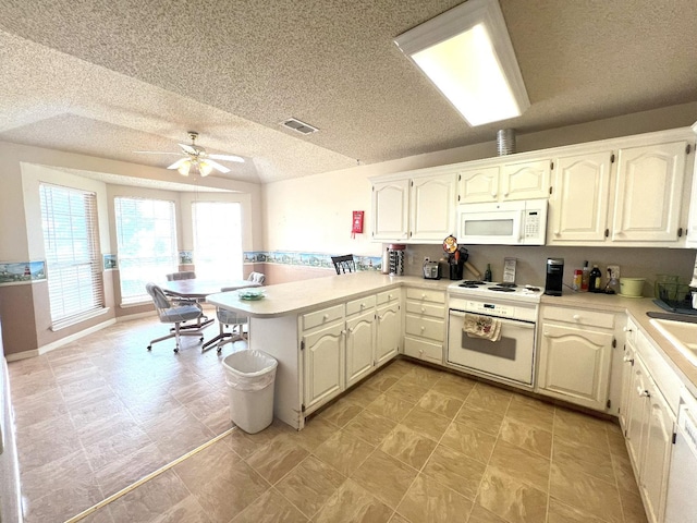 kitchen featuring sink, white appliances, ceiling fan, kitchen peninsula, and a textured ceiling