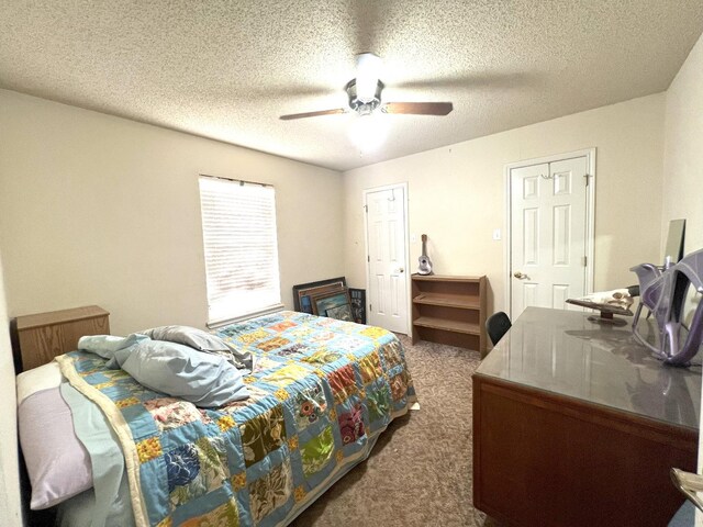 bedroom featuring ceiling fan, a textured ceiling, and dark carpet