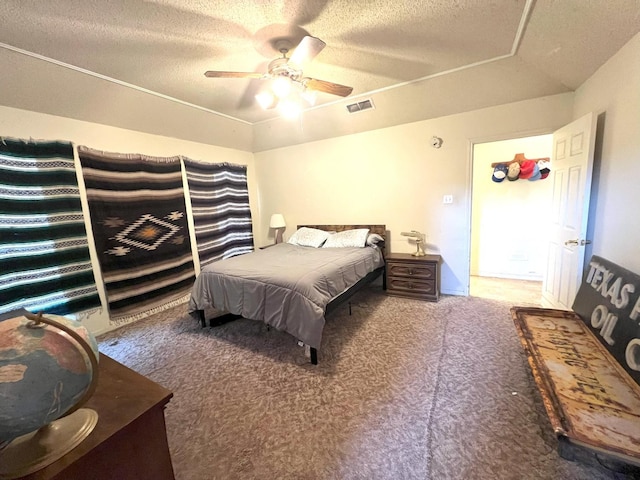 carpeted bedroom featuring ceiling fan and a textured ceiling