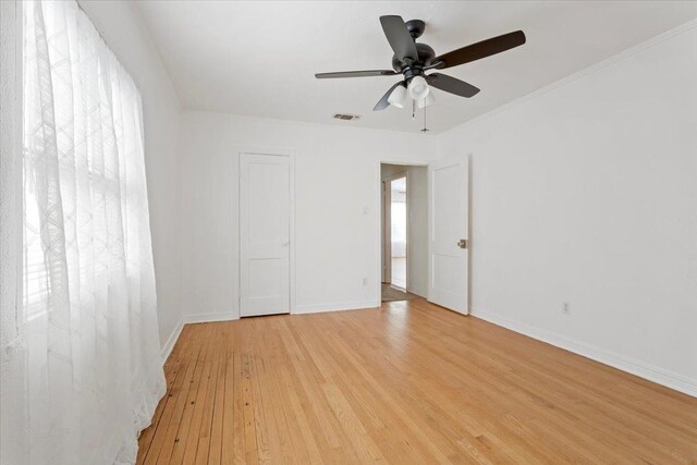 empty room with ornamental molding, ceiling fan, and light hardwood / wood-style flooring