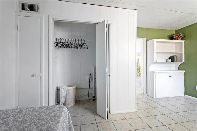 bedroom featuring light tile patterned flooring and a closet