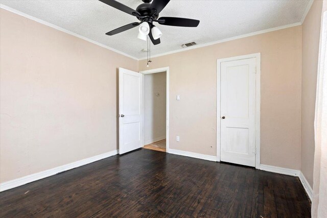 unfurnished room featuring crown molding, dark wood-type flooring, and a textured ceiling