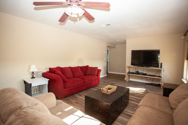 living room with dark wood-type flooring and ceiling fan