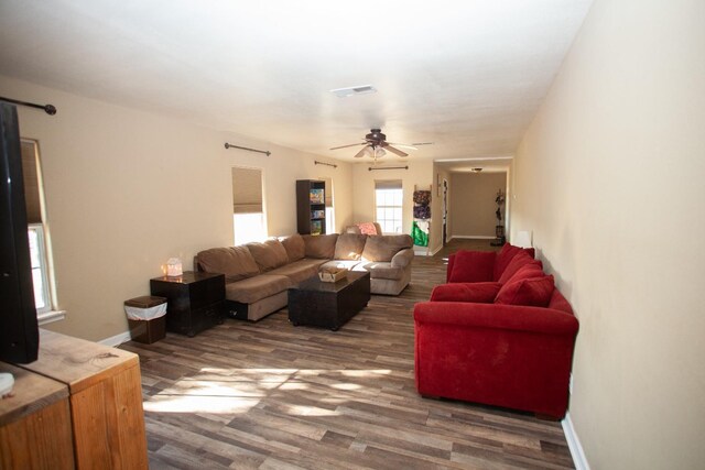 living room featuring ceiling fan and dark hardwood / wood-style flooring