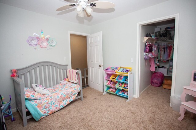 bedroom with a spacious closet, light carpet, ceiling fan, and a closet