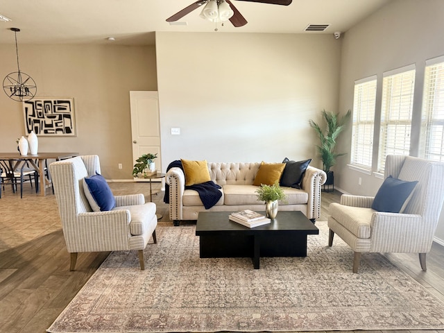 living area featuring ceiling fan, wood finished floors, visible vents, and baseboards