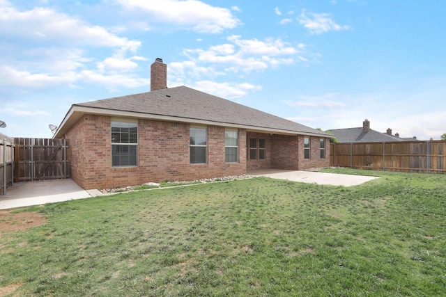 rear view of property with a patio, brick siding, a lawn, and a fenced backyard