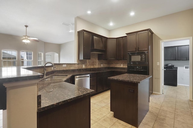 kitchen featuring premium range hood, a sink, dark brown cabinets, dark stone counters, and black appliances