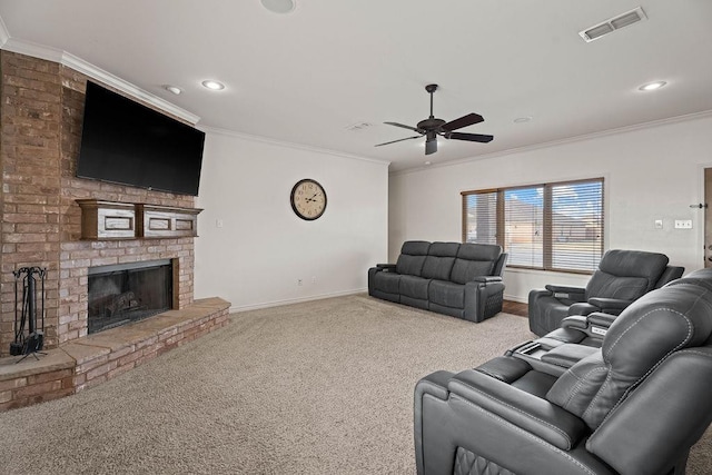 living room featuring crown molding, ceiling fan, a fireplace, and carpet