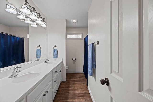 bathroom with hardwood / wood-style flooring, vanity, and toilet