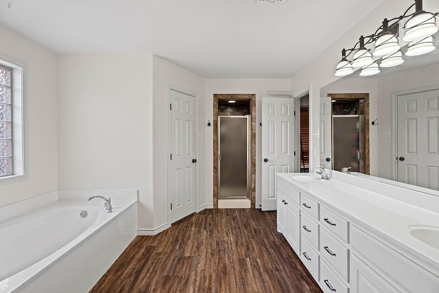 bathroom with wood-type flooring, shower with separate bathtub, and vanity