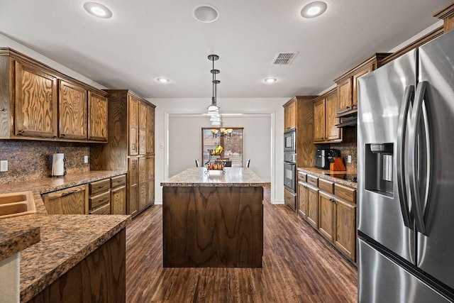 kitchen with a kitchen island, pendant lighting, backsplash, dark hardwood / wood-style flooring, and stainless steel fridge with ice dispenser