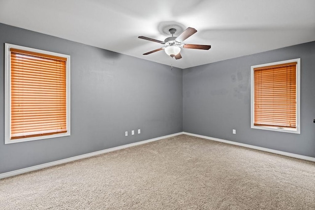 carpeted spare room with ceiling fan