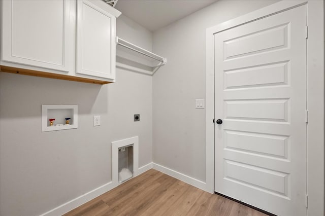 washroom featuring electric dryer hookup, washer hookup, light hardwood / wood-style floors, and cabinets