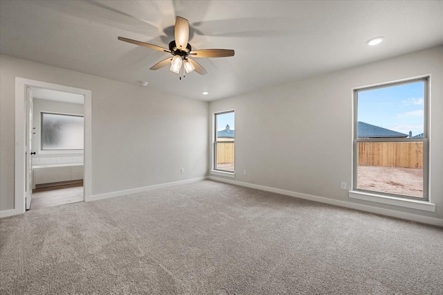 carpeted spare room with ceiling fan and a healthy amount of sunlight