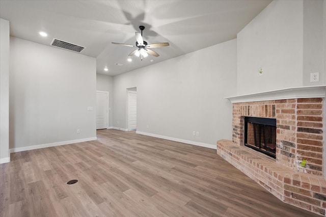 unfurnished living room with hardwood / wood-style floors, a fireplace, and ceiling fan