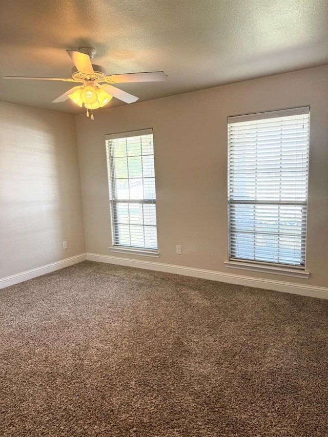 carpeted spare room with ceiling fan and a textured ceiling