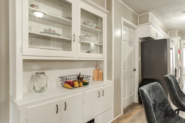 bar with white cabinetry and light hardwood / wood-style floors