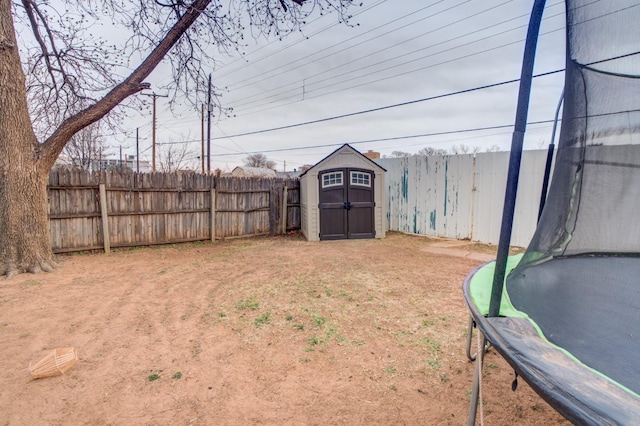 view of yard featuring a trampoline and a shed