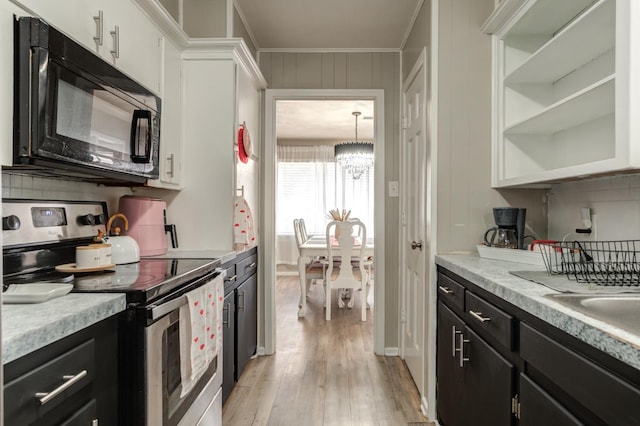 kitchen featuring white cabinetry, stainless steel electric range oven, light hardwood / wood-style floors, and a notable chandelier