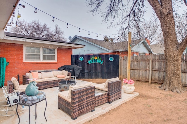 view of patio with an outdoor living space with a fire pit