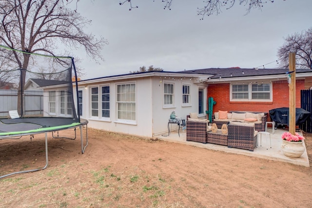 rear view of house with a patio, outdoor lounge area, and a trampoline