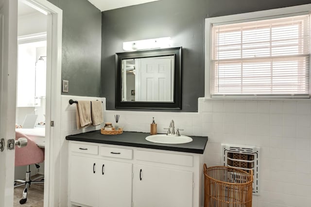 bathroom with vanity, heating unit, and decorative backsplash