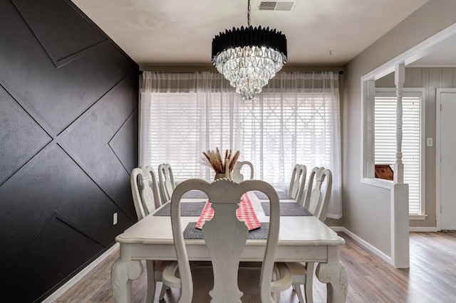 dining area with a wealth of natural light, a chandelier, and light hardwood / wood-style floors