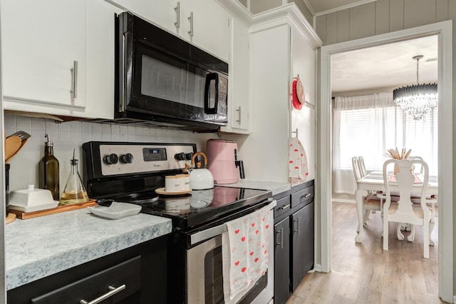 kitchen with hanging light fixtures, stainless steel range with electric cooktop, light hardwood / wood-style floors, and white cabinets