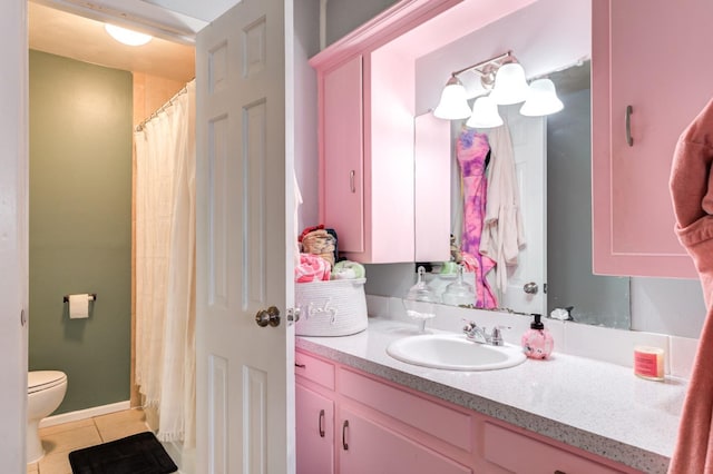 bathroom with tile patterned flooring, vanity, and toilet