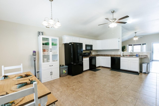 kitchen featuring lofted ceiling, sink, black appliances, white cabinets, and decorative light fixtures