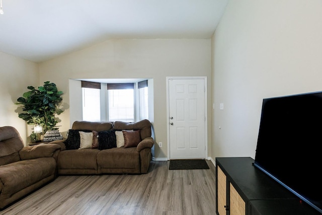 living room with vaulted ceiling and light wood-type flooring