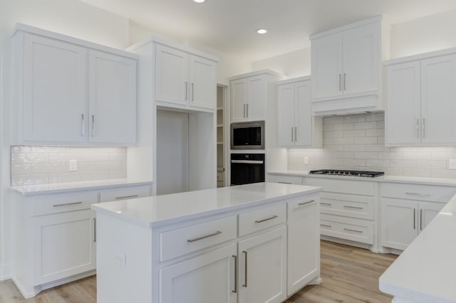 11806 Kenosha Ave, Lubbock, TX 79423 - kitchen featuring oven, stainless steel microwave, backsplash, white cabinets, and recessed lighting