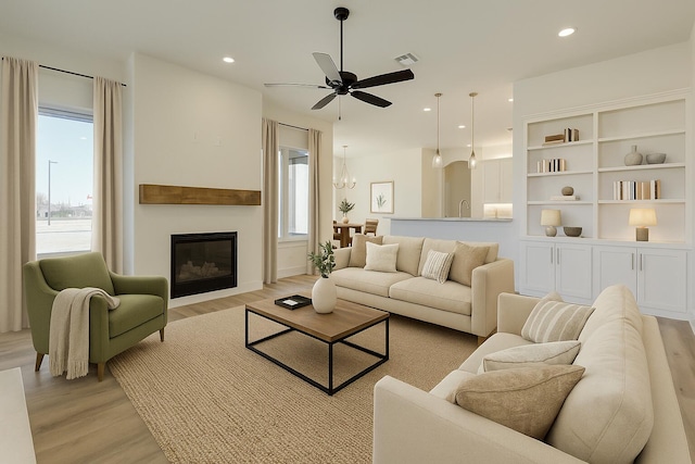 11806 Kenosha Ave, Lubbock, TX 79423 - living area with light wood-style floors, ceiling fan, recessed lighting, and a glass covered fireplace